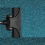 Carpet cleaning services - arial view of vacuum head on blue carpet